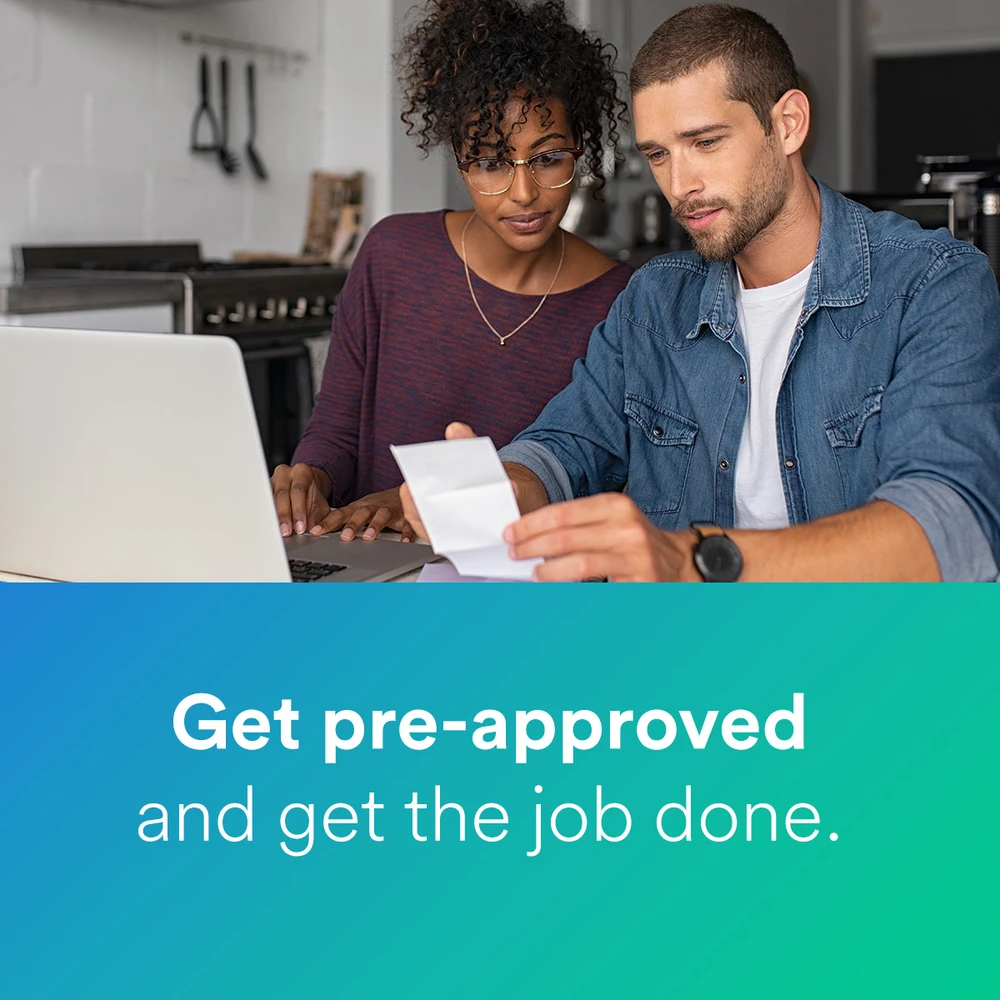 A couple reviewing financing options together on a laptop at their kitchen table — get pre-approved and get the job done